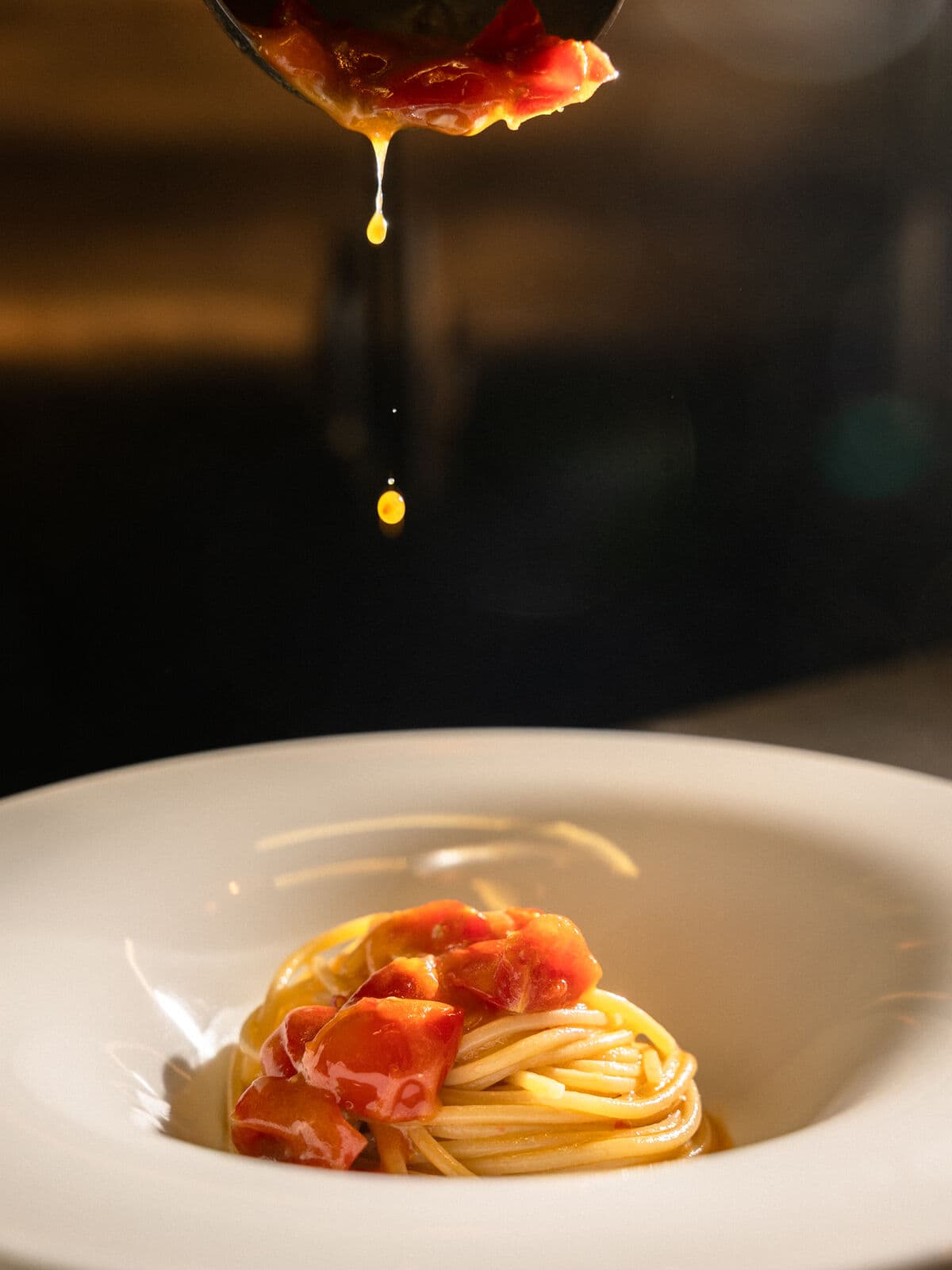 Sugo di pomodoro che cola su un nido di spaghetti